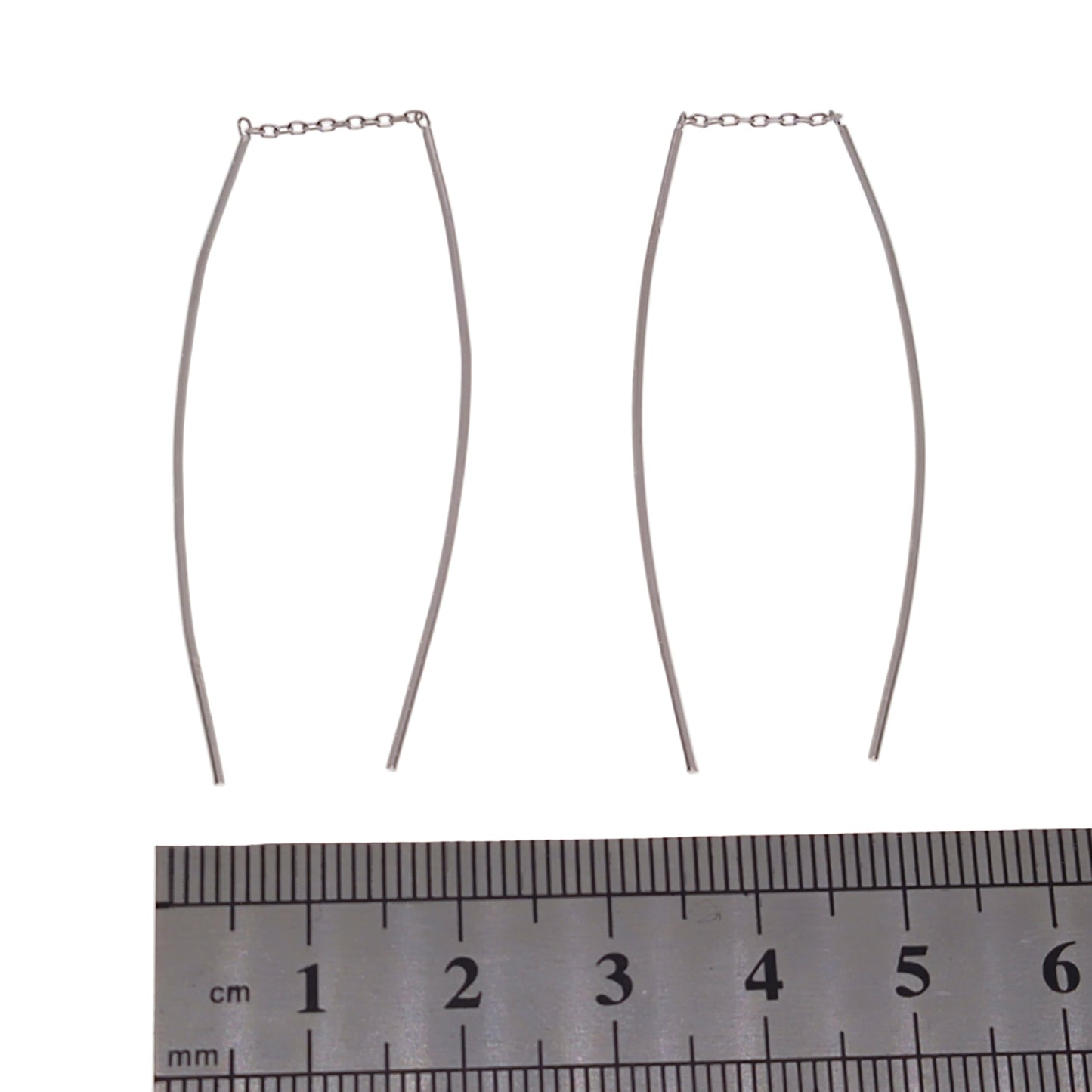 Sterling silver threader earrings with a ruler for scale on a white background