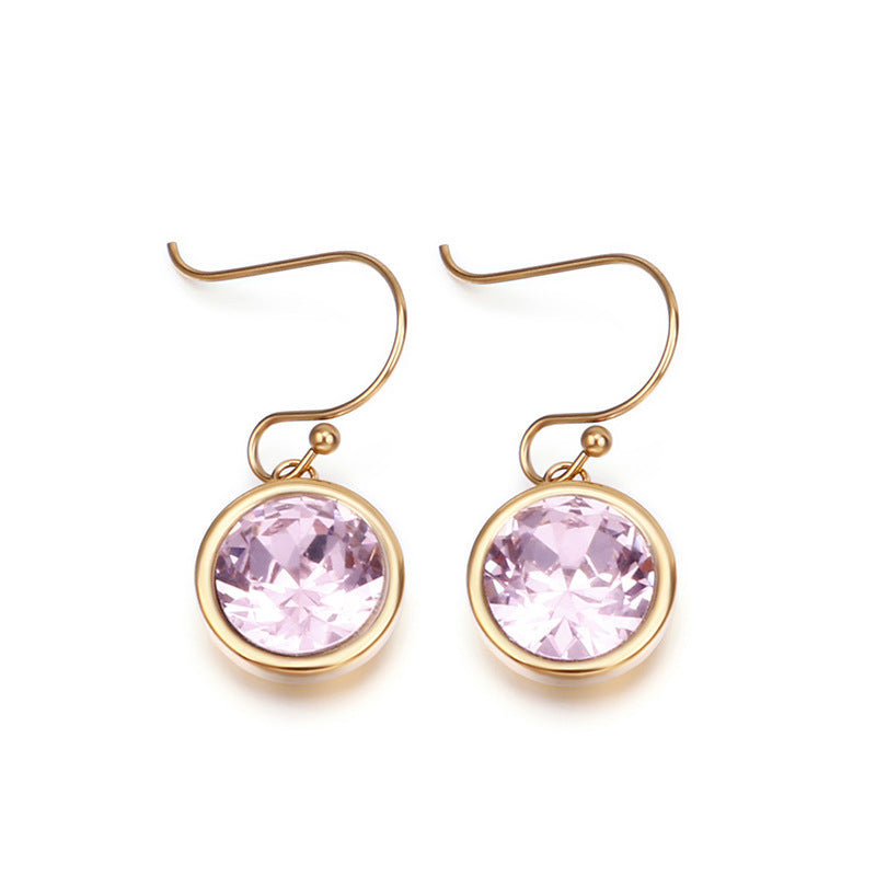 Gold earrings with pink gemstones on a white background