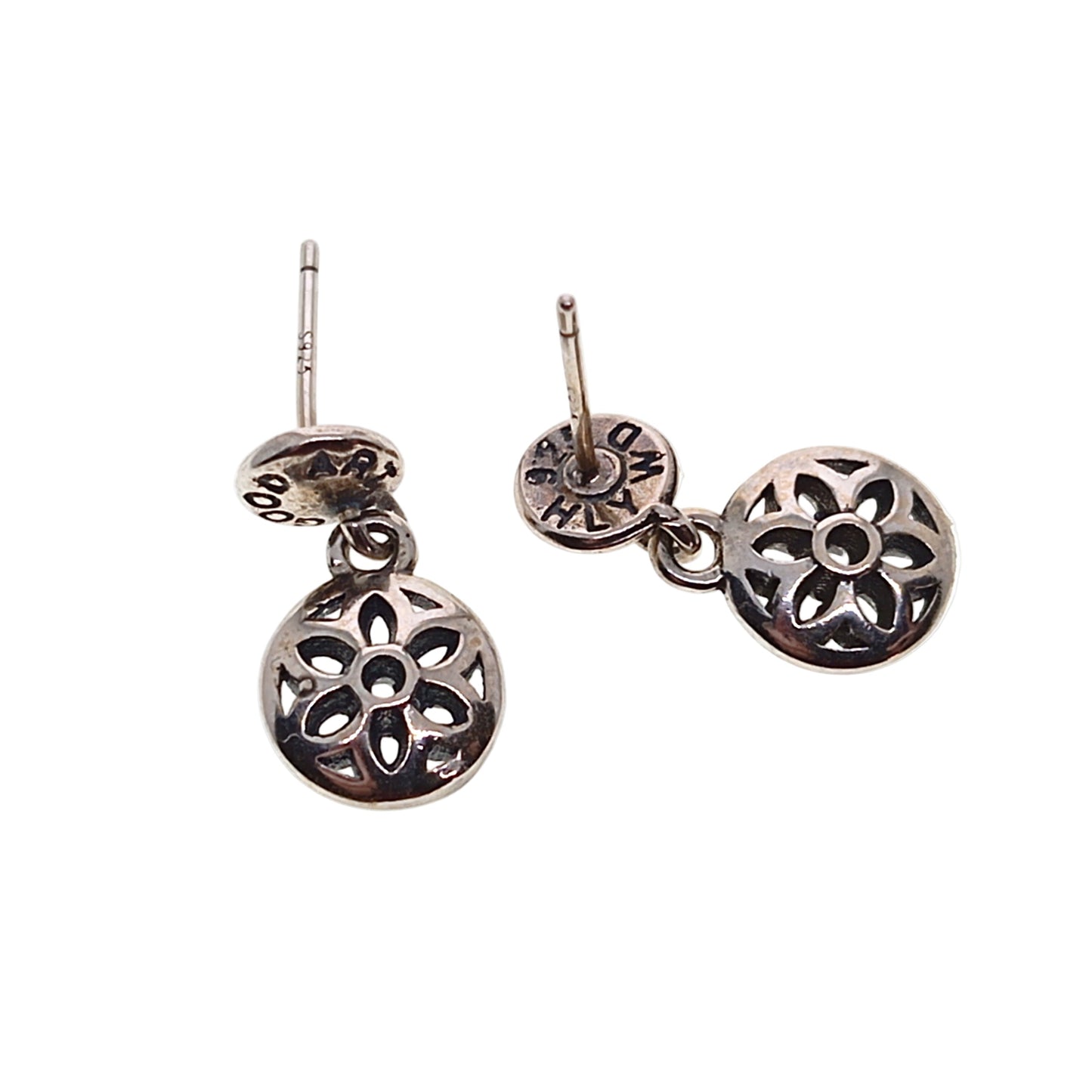 Pair of silver earrings with floral designs on a white background