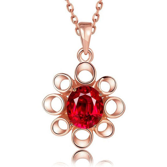 Rose gold necklace with a red gemstone pendant on a white background