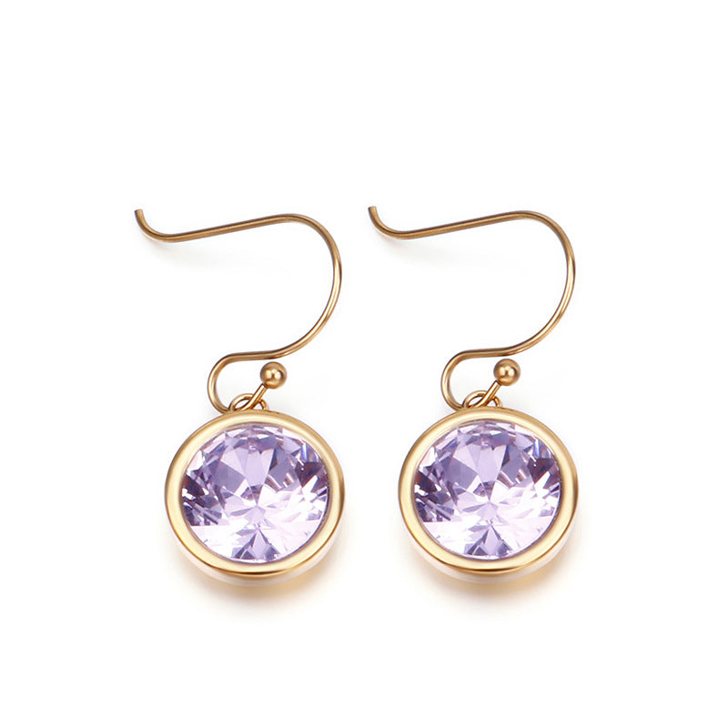 Gold earrings with purple gemstones on a white background