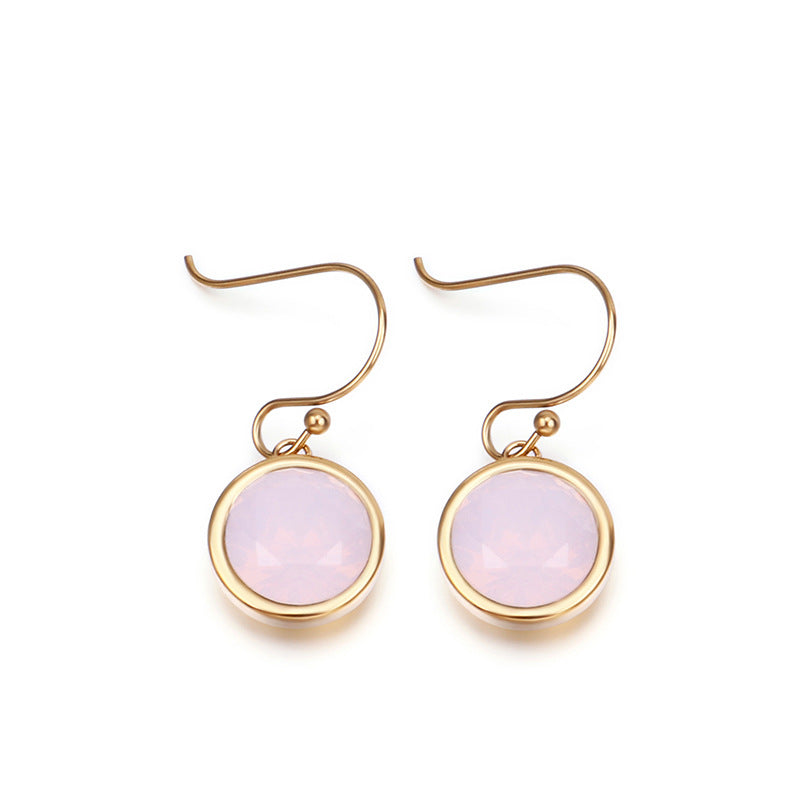 Gold earrings with pink gemstones on a white background