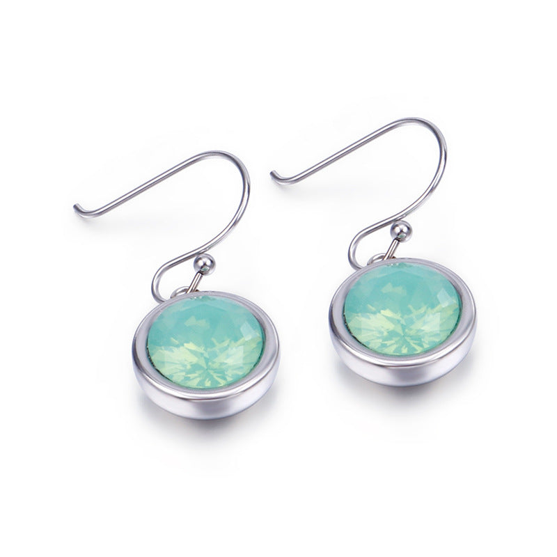 Pair of silver earrings with green gemstones on a white background