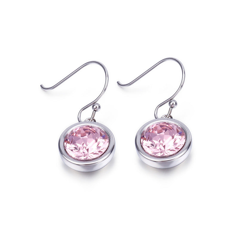Pair of silver earrings with pink gemstones on a white background