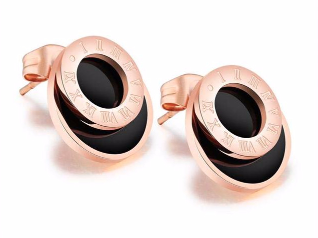 Pair of earrings with rose gold and black design on a white background