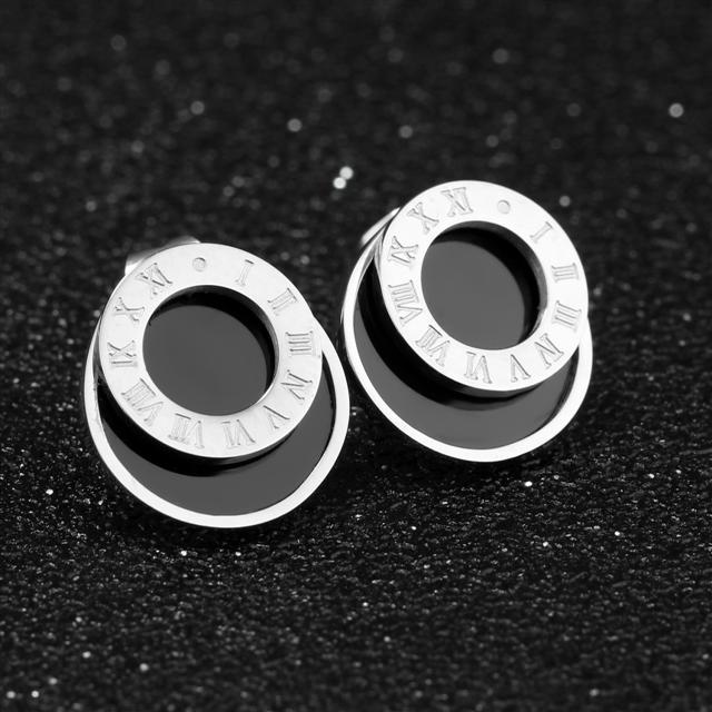 Pair of silver hoop earrings with Roman numeral design on a black textured background