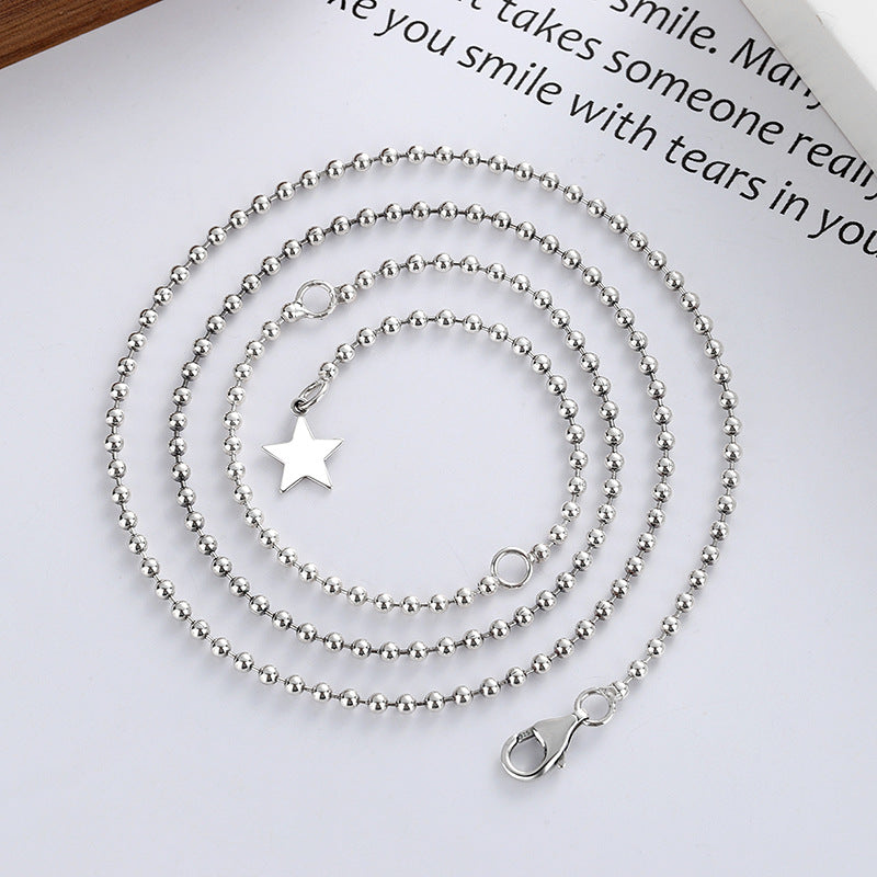 A sterling silver necklace with a star-shaped pendant, displayed on a flat surface.