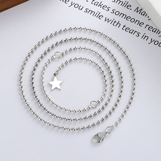 A sterling silver necklace with a star-shaped pendant, displayed on a flat surface.
