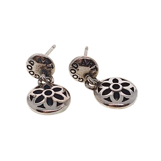 Pair of silver earrings with floral designs on a white background
