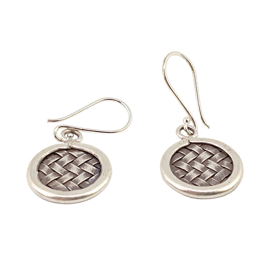 Pair of silver earrings with woven design on a white background